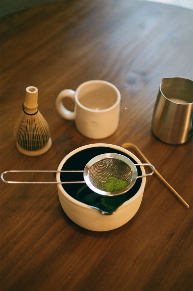 Matcha making tools are neatly arranged on wood.